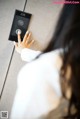 A woman is pressing a button on a wall.