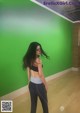 A woman standing in front of a green wall.