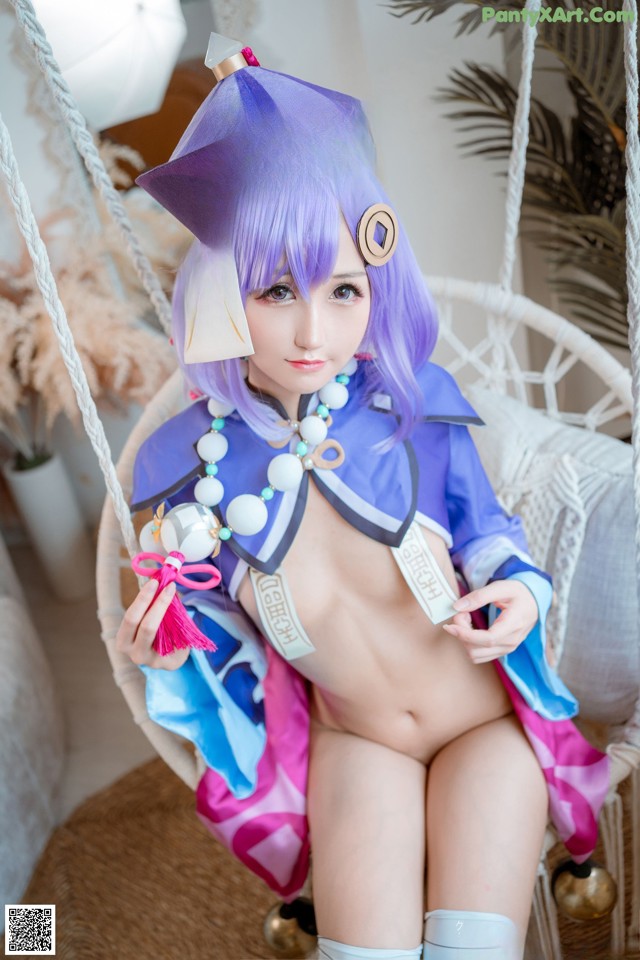 A woman in a blue and purple outfit sitting on a swing.