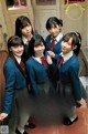 A group of young women in school uniforms posing for a picture.