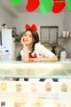 A woman sitting at a counter in a bakery.