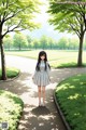 A girl in a white dress walking down a path in a park.