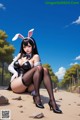 A woman in a bunny costume sitting on the ground.