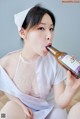 A woman in a nurse outfit drinking from a bottle.