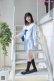 A woman in a school uniform standing on a set of stairs.