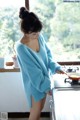 A woman standing in front of a stove holding a frying pan.