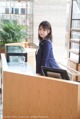 A woman standing at the front desk of a hotel.