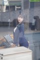 A woman in a business suit standing behind a counter.