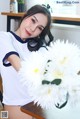 A woman sitting at a table with a bunch of flowers.