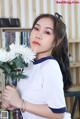 A woman holding a bunch of white flowers in her hand.