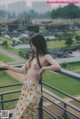 A woman standing on a balcony with her hands on her hips.