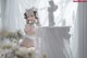 A woman in a white lingerie sitting on a table.