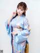 A woman in a blue kimono posing for a picture.