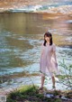 A woman standing in front of a body of water.